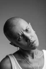 emotional studio portrait of a young attractive bald girl black and white image