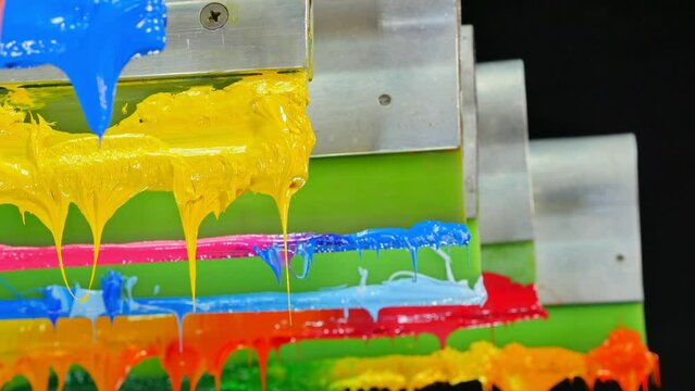 colorful plastisol ink stick on printer handle. .tee shirt factory always use plastisol ink to print on tee shirt ang any fabric..beautiful colors background. studio shot. dripping colorful paint.