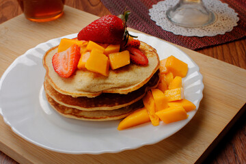 Hotcakes served ready for breakfast. Hotcakes decorated with strawberries.