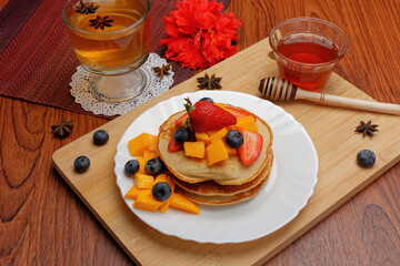 Hotcakes served ready for breakfast. Hotcakes decorated with strawberries.