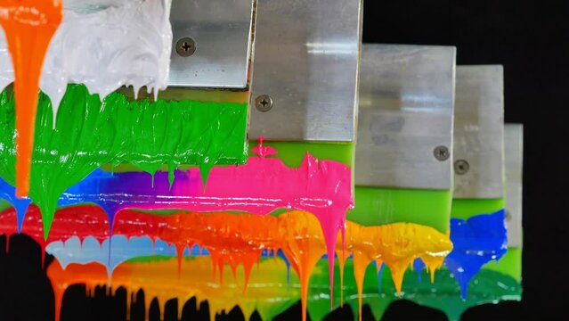 green and white ink hang on handle printer...tee shirt factory always use plastisol ink to print on tee shirt..studio shot.beautiful colors background.dripping colorful paint.