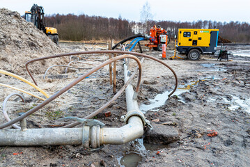 Wellpoint installation to get rid of high groundwater, visible metal and plastic pipes.