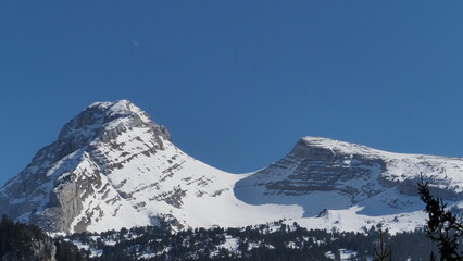 pass between two summits in the alps, with snow and blue sky