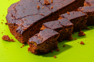 Sweet chocolate cake isolated on green background. Tasty creamy cake.