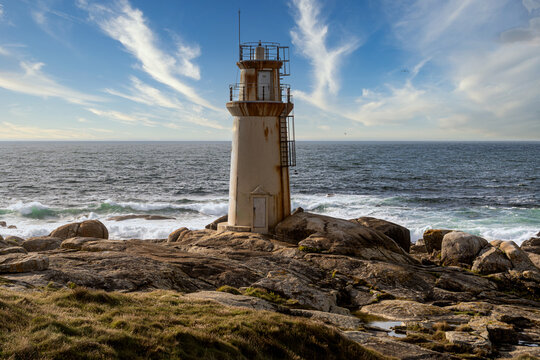 View of an old lighthouse with the ocean in the background, in Galicia, Spain.