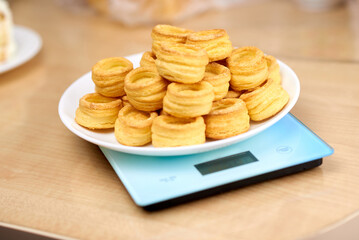 A vol-au-vent dish lies on the blue scales. Calorie counting concept, figure tracking