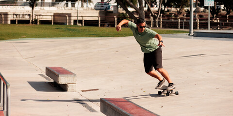 Man riding skateboard in urban street skatepark. Casual guy wearing shorts and T-shirt.