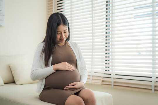 Pregnant woman sitting near the window at hospital.