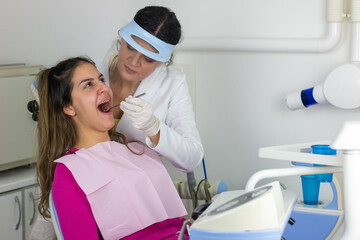  Teenager girl having her teeth checked by doctor