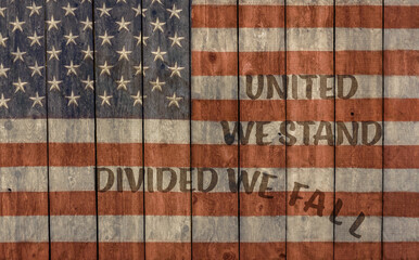 Vintage American flag United we stand divided we fall painted on old barn wall