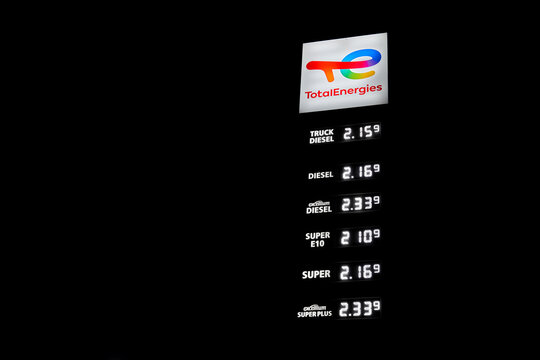Price board with high gasoline, diesel and fuel prices. Most expensive gas and oil prices at German Total Energies gas stations (tankstelle) in Europe. Isolated on black night.