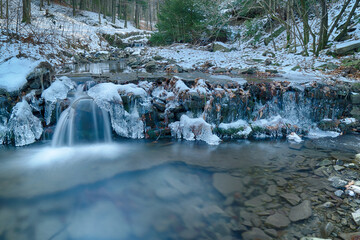 Mountain stream at the turn of winter and spring