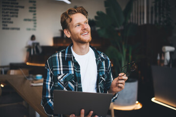 Young caucasian guy using laptop in office space