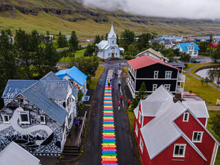 Beautiful aerial view of the town of Seydisfjordur and its Blue church and rainbow street, pier and cruise ships
