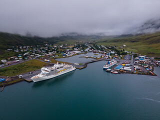 Fototapeta premium Beautiful aerial view of the town of Seydisfjordur and its Blue church and rainbow street, pier and cruise ships 
