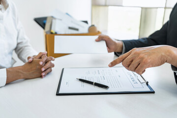 Close up of the hand employer focus the employee to write a letter of resignation and filing final remuneration, resign concept
