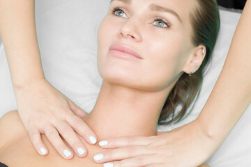 The girl gets a massage of the neck, the decollete area.