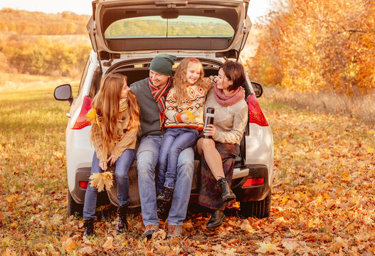 Family sitting in car trunk