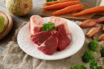 Ingredients for beef bone broth or soup - fresh marrow bones, meat and vegetables