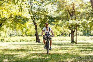 Obraz premium A happy father driving son on a bicycle in nature on earth's day.