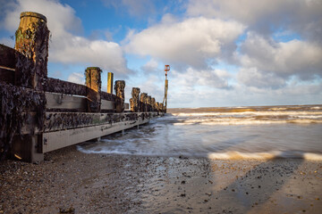 Fototapeta premium Long exposure image of wooden sea breakers or groynes on Cromer beach on the North Norfolk coast
