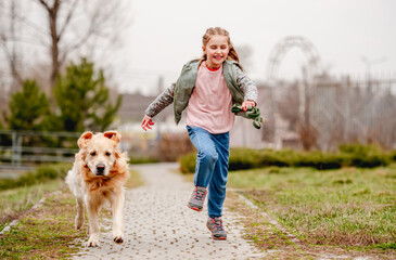 Little girl with golden retriever dog outside