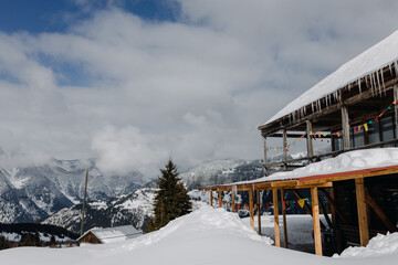  Village in the mountains. Two-story wooden house against the backdrop of snow-capped mountains.