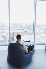 Concentrated young businessman looking at laptop screen, information online or working remotely...