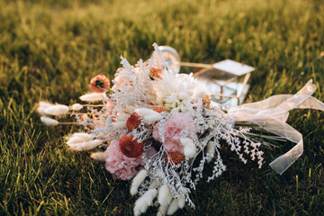 Bride's wedding bouquet in boho style on green grass