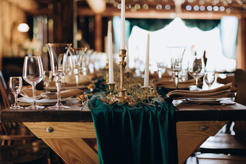 Elegant wooden wedding table for dinner in rustic style with candles