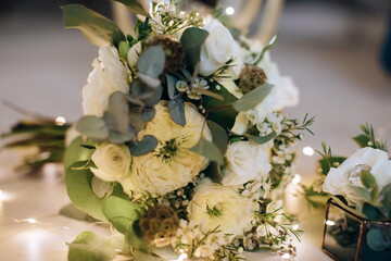Elegant wedding bouquet of the bride of white roses with light
