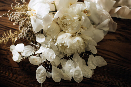 Wedding bouquet of white peonies on a wooden table