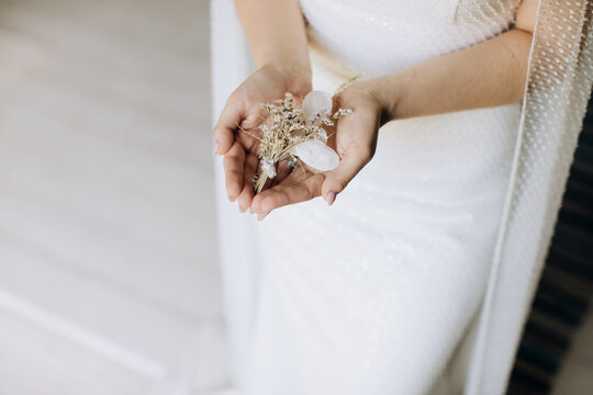 Beautiful White boutonniere in the hands of the bride