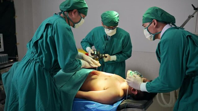 Team of doctor helping by AED defibrillation with accident injured patient unresponsive in emergency room