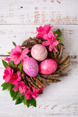 Fototapeta na wymiar Easter Eggs Dyed with Various Patterns of Pink Silk Surrounded by Pink Azaleas on a White Background