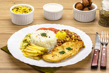 plate with typical Brazilian meal, fried chicken fillet, rice with beans and salad, farofa and fried egg, Brazilian executive lunch served in restaurants