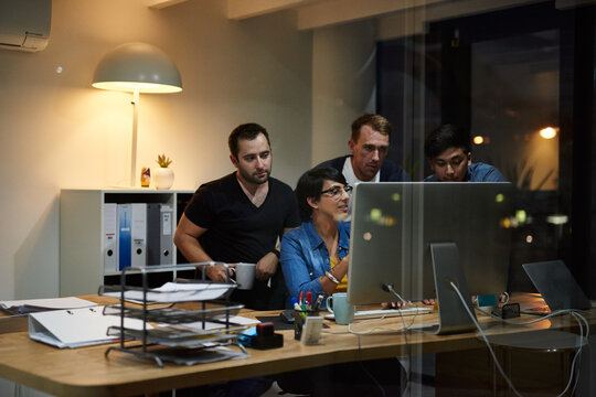 Theyre Driven To Succeed Together. Shot Of Employees Working In An Office At Night.