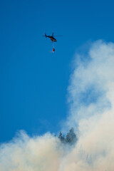 Fototapeta na wymiar Forest fires, helicopters working through the intense smoke to control the fire.