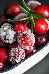 Fresh cranberries decorated with sugar and rosemary. Frozen cranberries. Festive background. Christmas card.