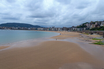 wide sandy beach, calm sea, cloudy sky. San Sebastian. Spain