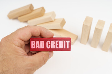 In the foreground, a hand with a red wooden block and the inscription - bad credit