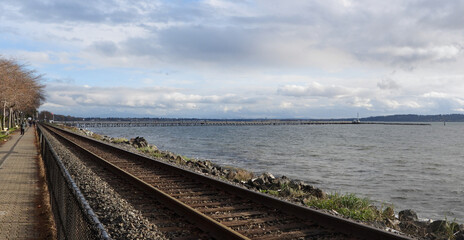 Fototapeta na wymiar Walking path along the seashore railway tracks