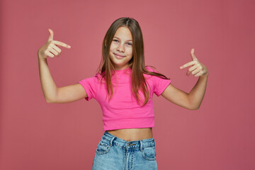 Cool confident child girl pointing to herself, proud of own success, gesturing like a rapper on pink studio background - obrazy, fototapety, plakaty