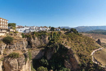 Fototapeta na wymiar The famous white village of Ronda located on El Tajo gorge from Ronda viewpoint at daylight, Malaga province, Andalusia, Spain