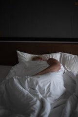 Mature sleeping man in his bed with white sheets. Good rest and healthy sleep at night