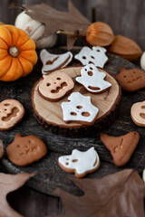 Homemade halloween holiday treats for kids. Gingerbread cookies on wooden board, decorated with pumpkins and autumn leaves. Top view
