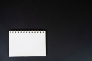 a blank spiral notebook on a black background	