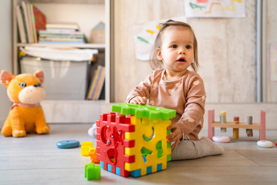 One Baby Small Caucasian Infant Girl Playing On The Floor At Home Copy Space