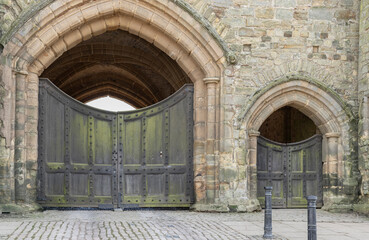 A large and small arched doorway of honey coloured stone - obrazy, fototapety, plakaty