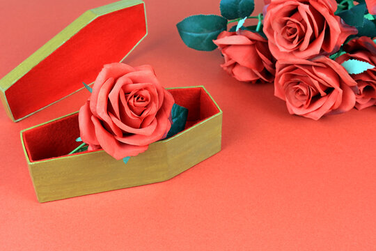 Artificial Red Rose In A Small Coffin. Funeral Flowers Concept.